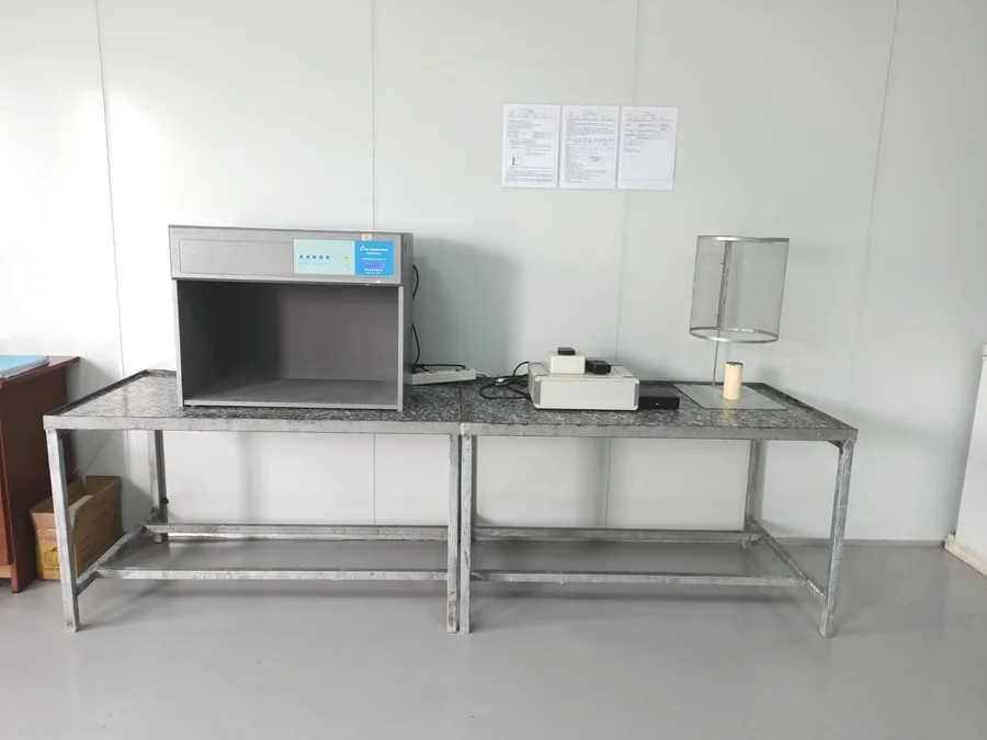 QC station with a color-matching light box and burn-test cage