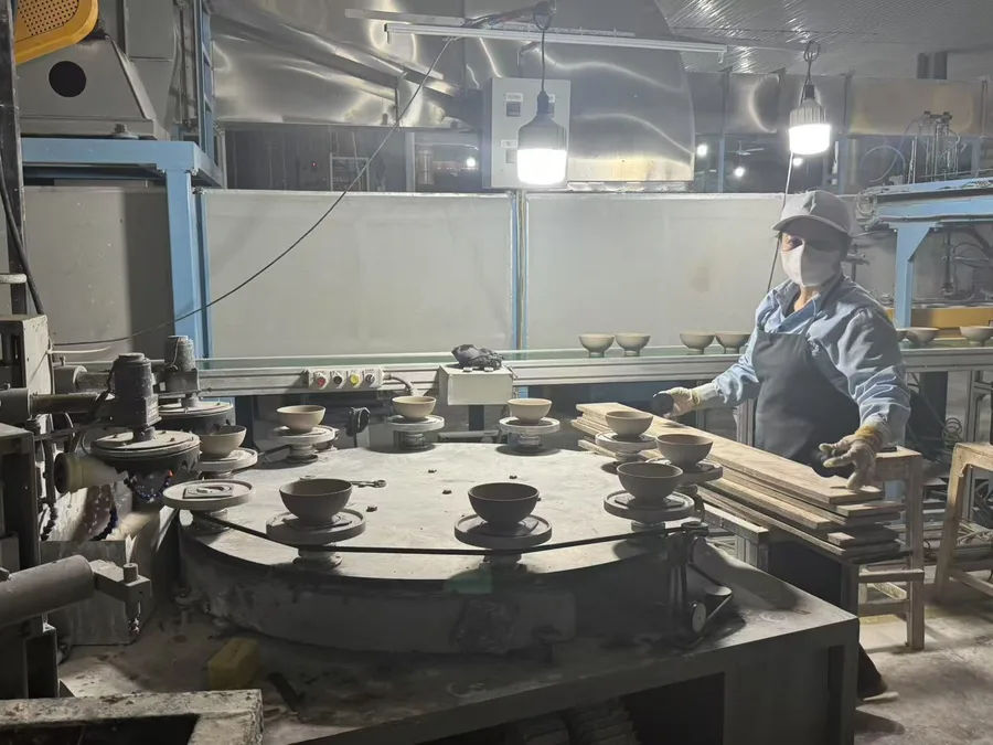 Machine jigger line forming stoneware bowls in Vietnam